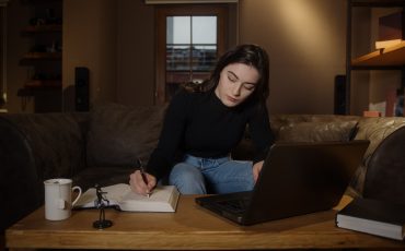 young-college-or-high-school-student-pretty-girl-studying-at-table-with-laptop-and-pen-paper